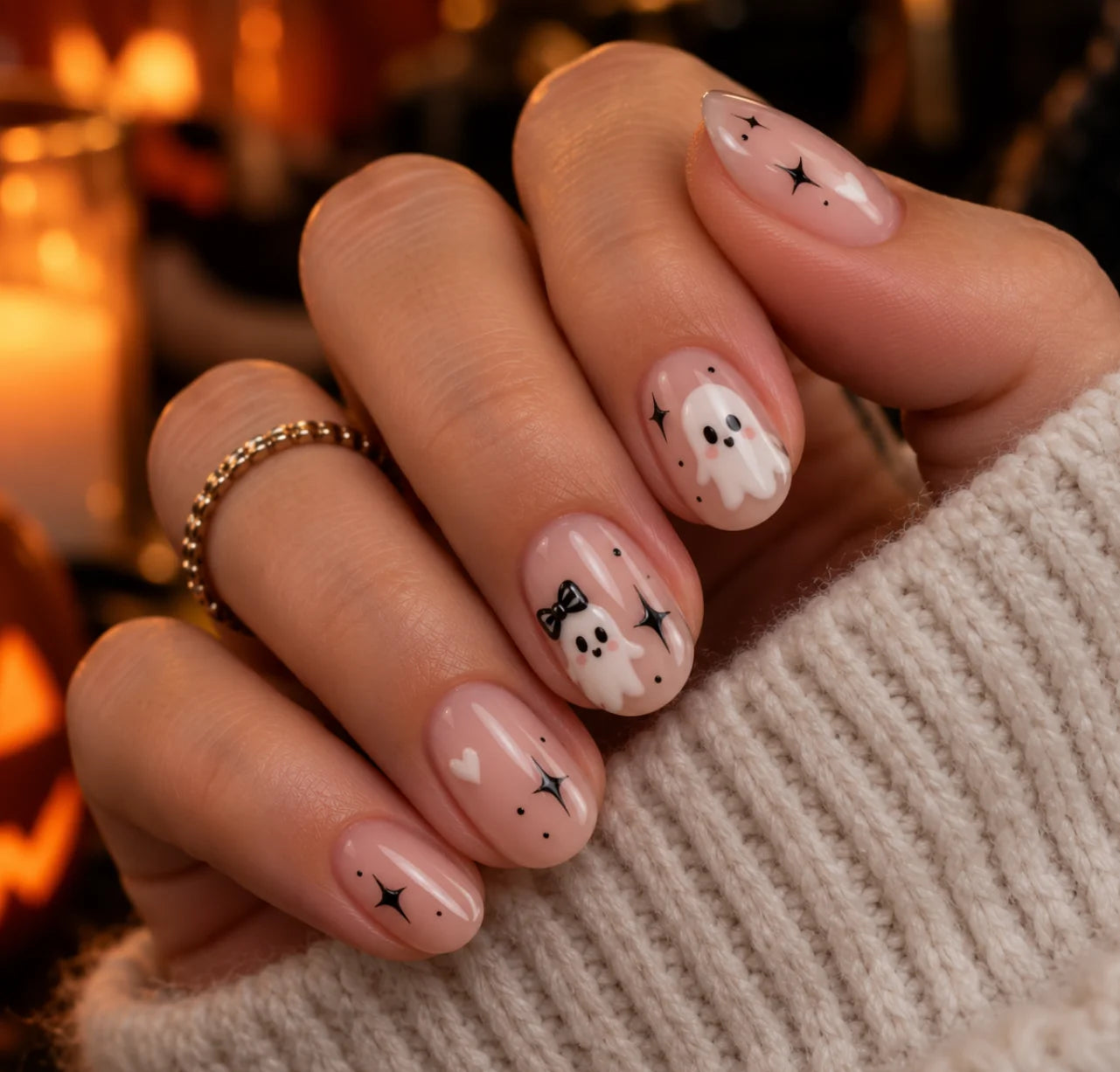 Milky nude nails with a small white ghost on the ring finger
